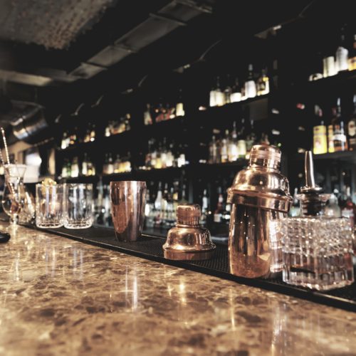 Classic bar counter with bottles in blurred background
